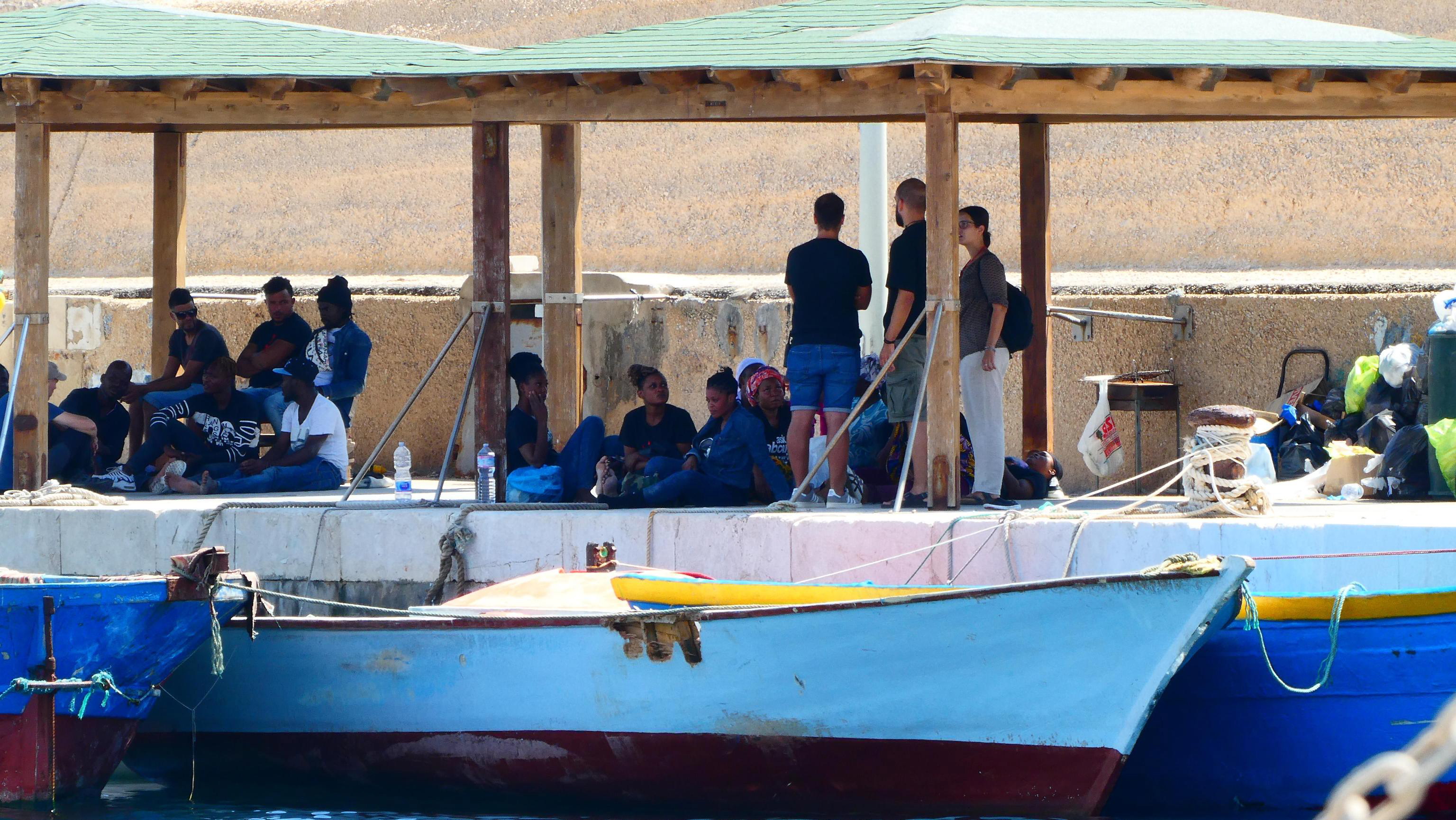 epa07812881 Migrants wait to diembark from a boat in Lampedusa harbour, Lampedusa, Italy, 02 September 2019. The three boats with a total of 143 migrants on board arrived in Lampedusa on 02 September 2019.  EPA/Elio Desiderio