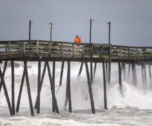 epa07824060 A worker returns after inspecting the Avalon Fishing Pier, which was damaged as Hurricane Dorian struck Kill Devil Hills, North Carolina, USA, 06 September 2019. The Category 1 storm struck the state's fragile barrier islands, the Outer Banks, for much of the day.  EPA/JIM LO SCALZO