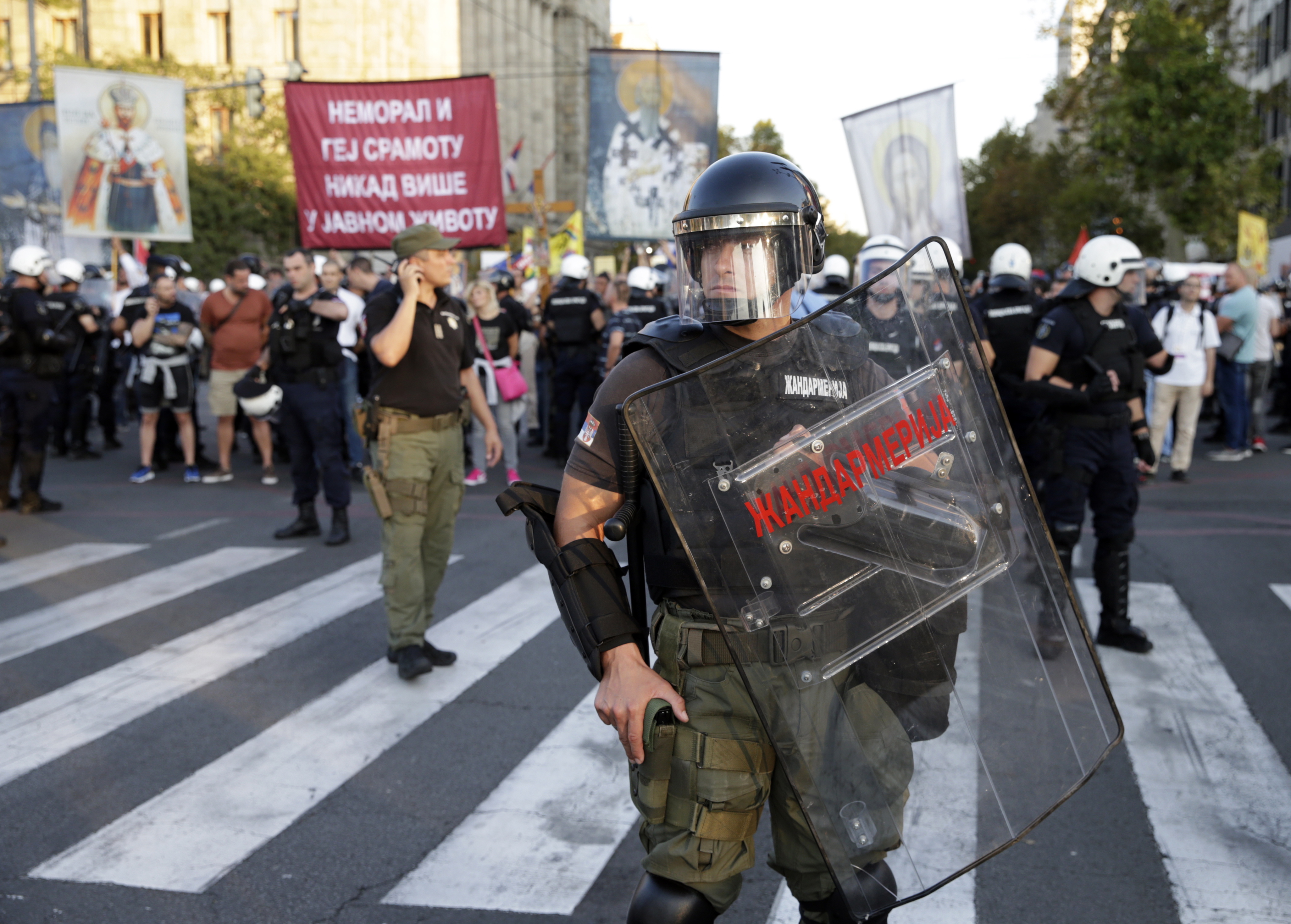 epa07845027 Participants wave a rainbow coloured flag as Riot police blocks off people protesting against the Pride parade during the Belgrade Pride Parade march in Belgrade, Serbia, 15 September 2019. Holding rainbow colored flags, balloons and banners with slogans such as 'I'm not giving up' pride participants marched the 10th time through the main streets of Serbia's capital near the main institutions in the city to which Belgrade Pride has been addressing its demands for improved rights for the LGBTI+ community.  EPA/ANDREJ CUKIC