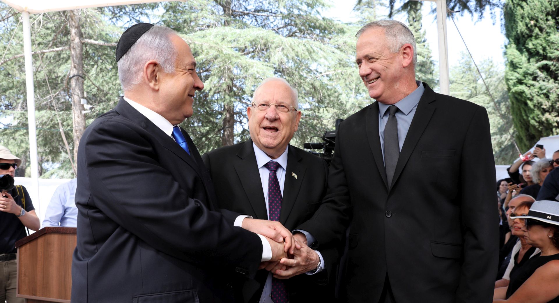 epa07852803 (L-R) Israeli Prime Minister Benjamin Netanyahu, Israeli President Reuven Rivlin and Benny Gantz, former Israeli Army Chief of Staff and chairman of the Blue and White Israeli centrist political alliance join hands as they attend a memorial service for late Israeli president Shimon Peres at Mount Herzl, Israel's national cemetery, in Jerusalem, 19 September 2019.  EPA/ABIR SULTAN