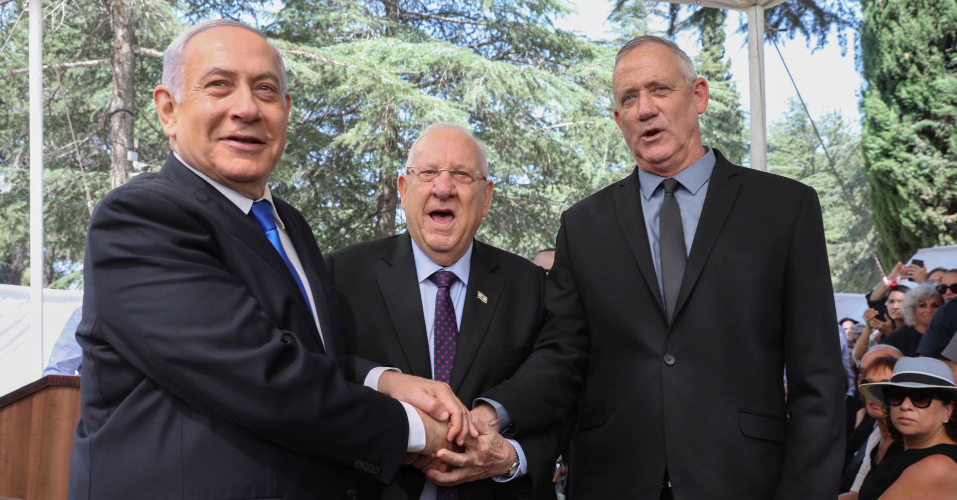 epa07852802 (L-R) Israeli Prime Minister Benjamin Netanyahu, Israeli President Reuven Rivlin and Benny Gantz, former Israeli Army Chief of Staff and chairman of the Blue and White Israeli centrist political alliance join hands as they attend a memorial service for late Israeli president Shimon Peres at Mount Herzl, Israel's national cemetery, in Jerusalem, 19 September 2019.  EPA/ABIR SULTAN