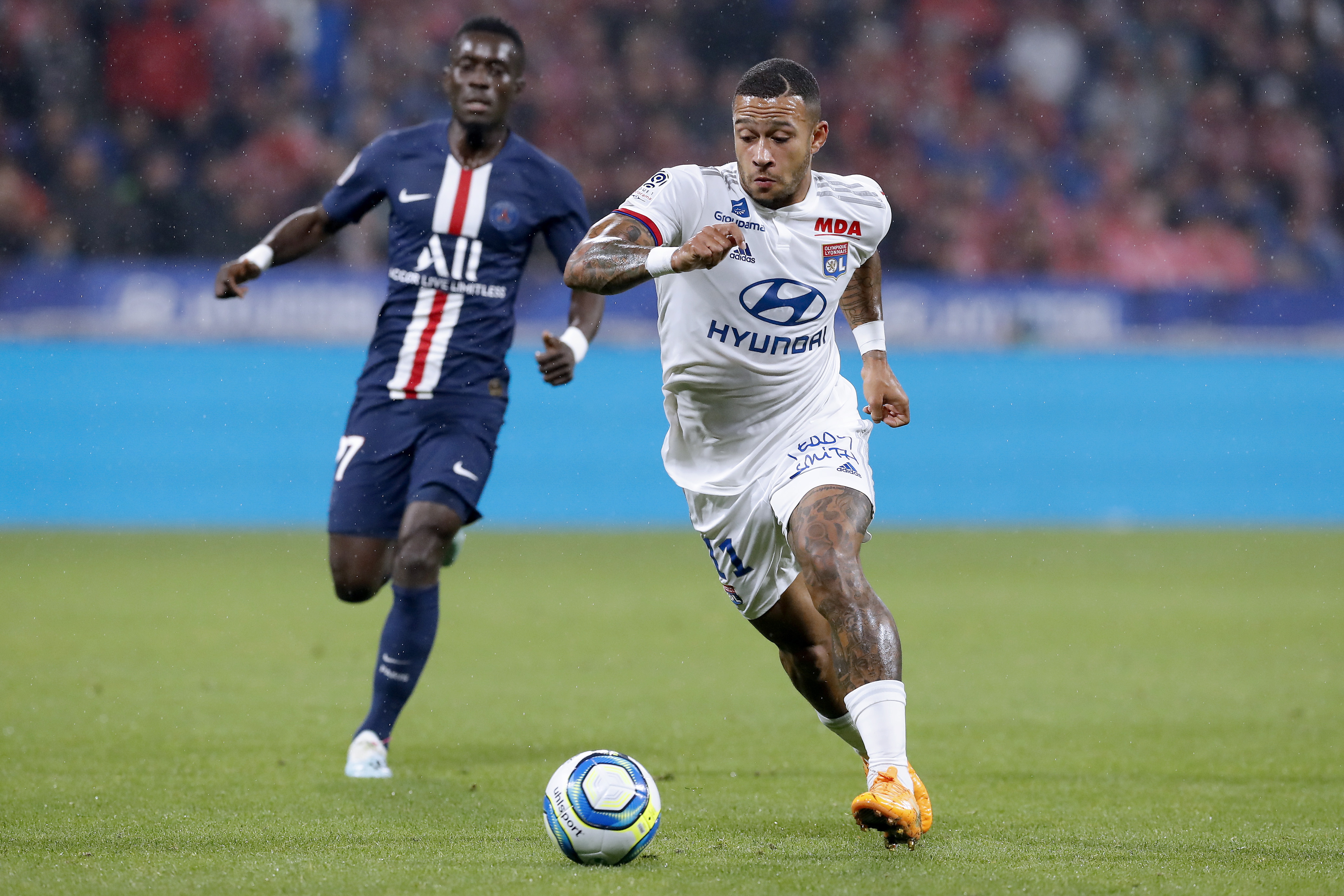 epa07862233 Lyon's Memphis Depay (R) and Paris Saint Germain's Idrissa Gueye (L) in action during the French Ligue 1 soccer match between Olympique Lyon and PSG at Parc Olympique Lyonnais stadium in Lyon, France, 22 September 2019.  EPA/SEBASTIEN NOGIER