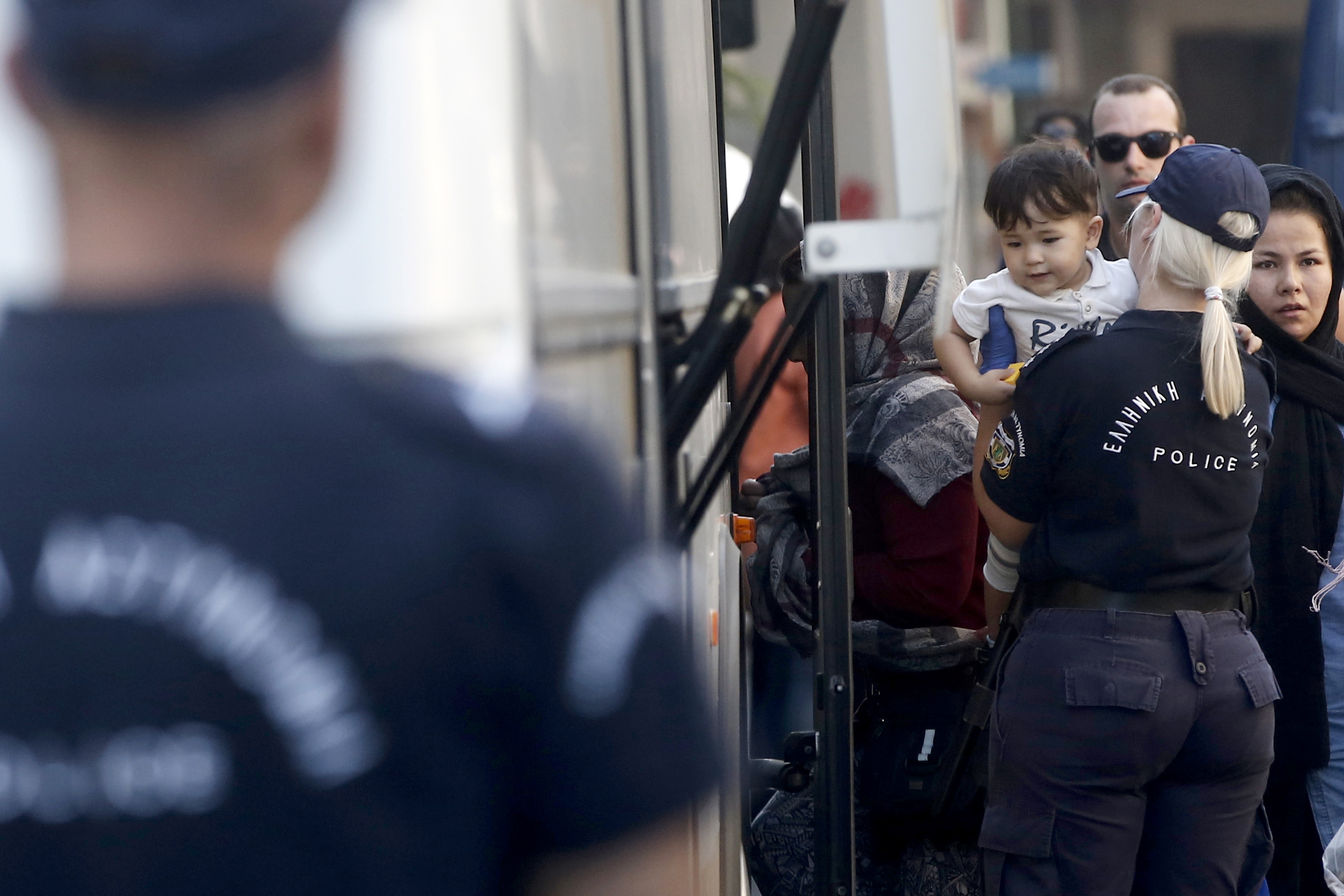 epa07853006 A police officer leads a refugee girl on a bus during a police operation evacuating buildings squatted mostly by migrant families in central Athens, Greece, 19 September 2019. A large police operation to evacuate buildings in downtown Athens squatted mostly by migrant families got underway on 19 September 2019 morning.  EPA/YANNIS KOLESIDIS