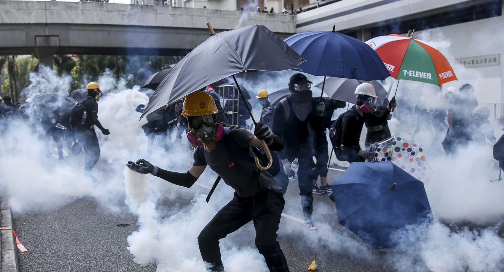 epa07884442 An anti-government protester tosses back a tear gas grenade during protests on National Day in Hong Kong, China, 01 October 2019. Hong Kong scaled down the Flag-Raising Ceremony and National Day Reception as the city has witnessed several months of ongoing mass protests, originally triggered by a now withdrawn extradition bill to mainland China that have turned into a wider pro-democracy movement.  EPA/JEROME FAVRE