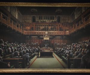 epa07873172 Gallery assistants pose as British artist Banksy's work "Devolved Parliament" is displayed at a photo-call at Sotheby's auction house in London, Britain, 27 September 2019. The work will be sold during the Contemporary Art Evening Auction on October 13 2019.  EPA/NEIL HALL