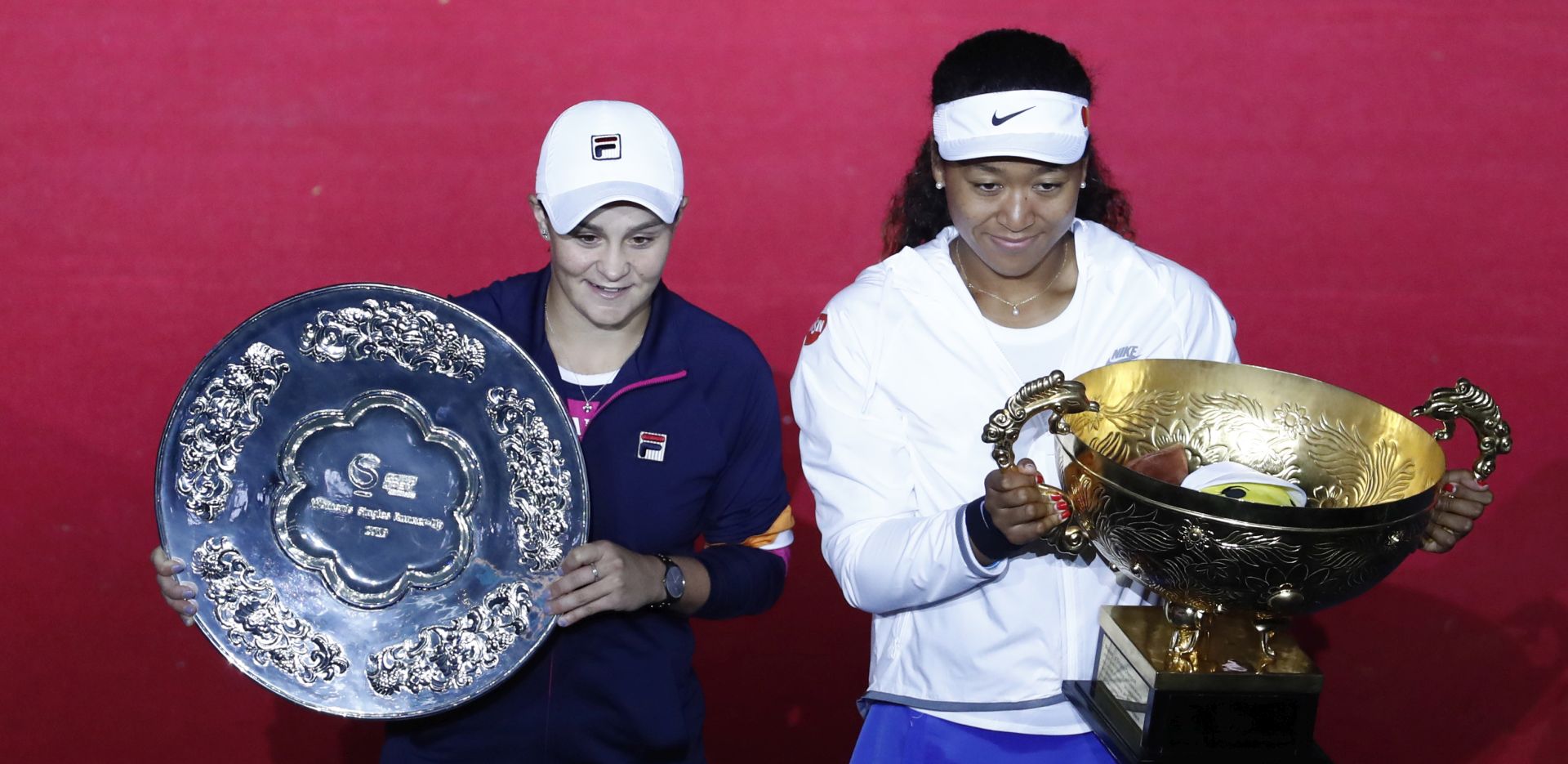 epa07900804 Naomi Osaka of Japan (R) celebrates with the trophy after winning her women's singles final against Ashleigh Barty of Australia (L) at the China Open tennis tournament in Beijing, China, 06 October 2019.  EPA/WU HONG