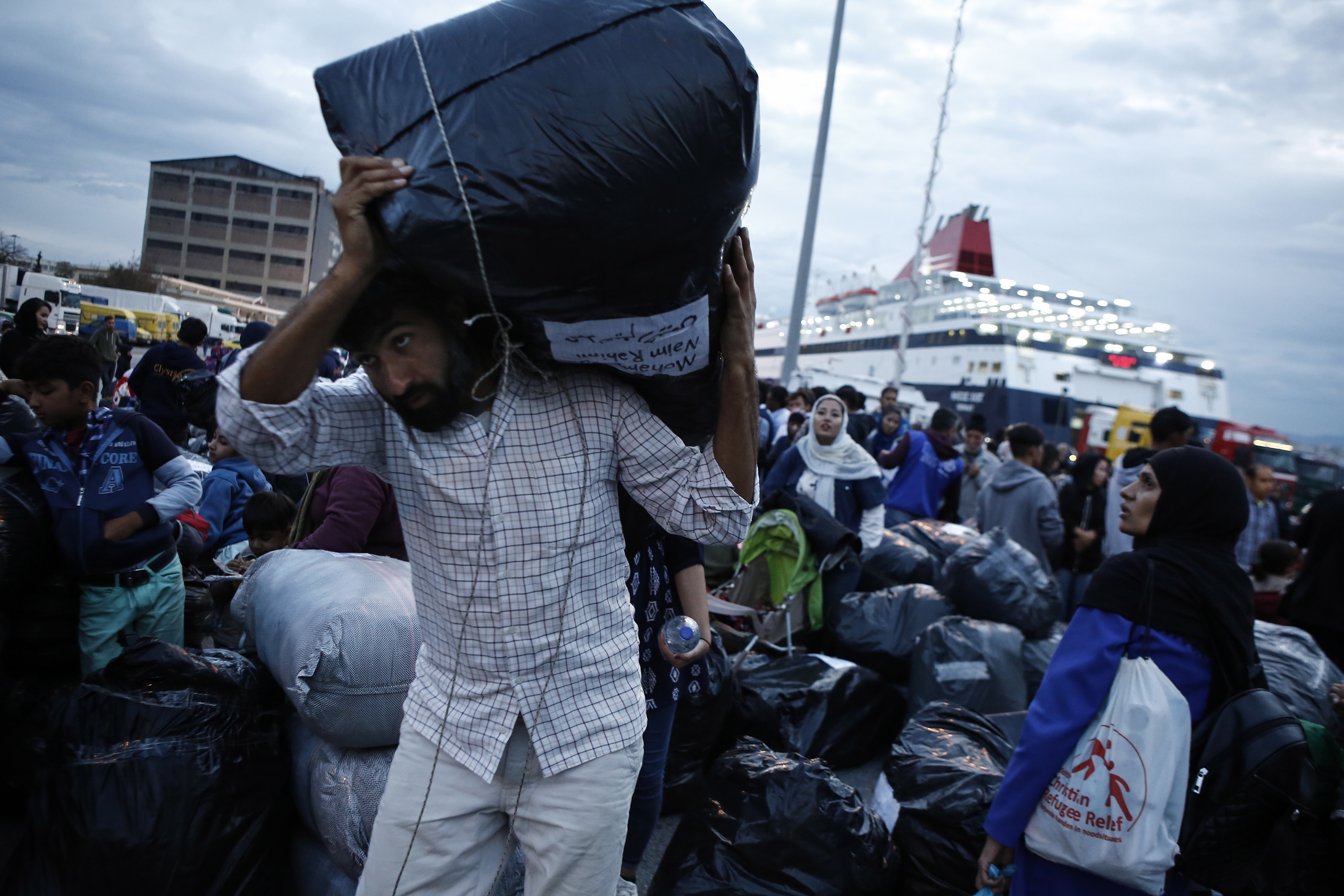 epa07902852 Migrants disembark from the ferry 'Nissos Samos' upon their arrival from Lesvos island to the port of Piraeus, Greece, 07 October 2019. The ferry arrived in Piraeus carrying 453 refugees and migrants from Moria, Lesvos and 13 from Chios Island, from the so-called vulnerable groups asking for asylum, who will be transferred to the village of Vagiohori, close to lake Volvi, in central Macedonia. The Moria reception and identification centre currently hosts 13,300 people, 1,000 of which are unaccompanied minors.  EPA/YANNIS KOLESIDIS