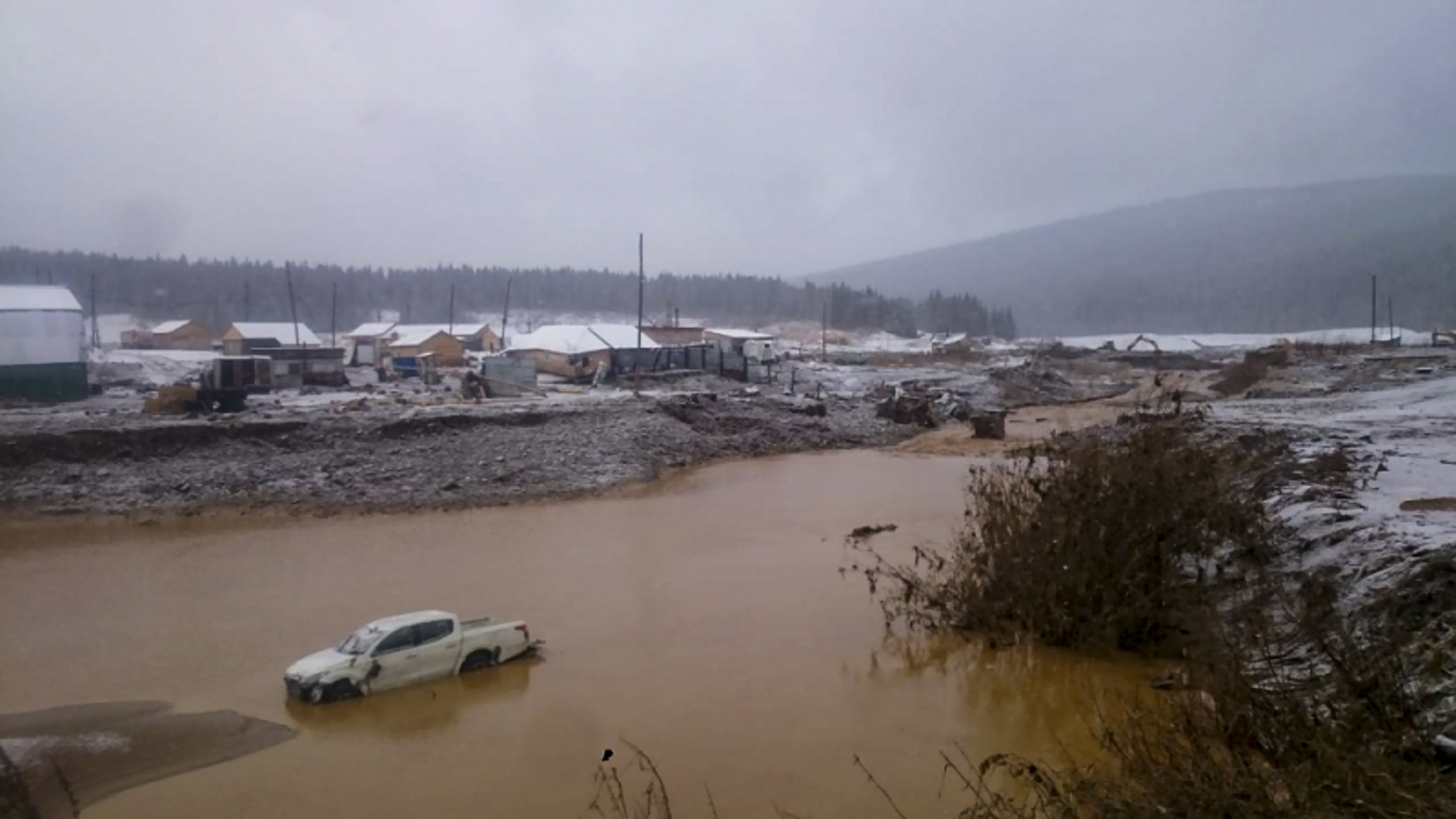 epa07932783 A handout photo made available by Russian Emergencies Ministry shows general view of destructions after a mining dam burst of gold mining technological reservoir, on the Seiba River near the village of Shchetinkino, Krasnoyarsk Region, Russia, 19 October 2019. Two mining workers dormitory was flooded as the dam collapsed, killing 12 people and leaving 13 workers still missing.  EPA/RUSSIAN EMERGENCIES MINISTRY / HANDOUT MANDATORY CREDIT HANDOUT EDITORIAL USE ONLY/NO SALES