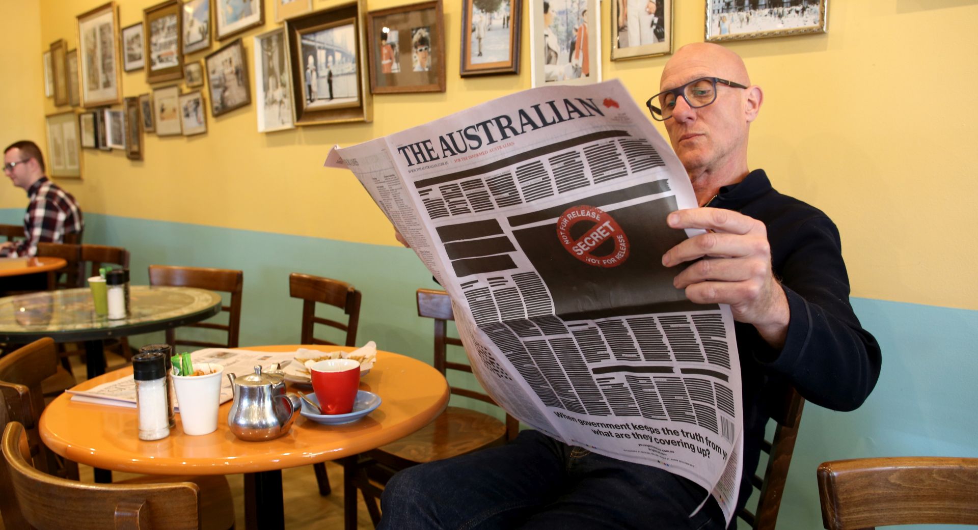 epa07937921 A man reads a copy of Australian newspaper 'The Advertiser' featuring a 'Your Right to Know' campaign illustration as part of a national media campaign, in Adelaide, Australia, 21 October 2019. The front pages of some major newspapers on 21 October replicated a heavily redacted government document, alongside an advertising campaign challenging laws that effectively criminalize journalism and whistleblowing.  EPA/KELLY BARNES  AUSTRALIA AND NEW ZEALAND OUT