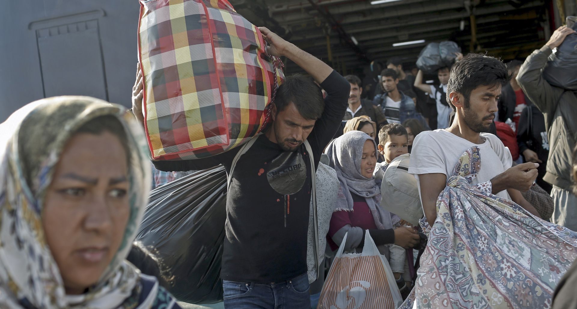 epa07940004 Migrants disembark from the ferry 'Paros Jet' upon their arrival from Samos Island at the port of Elefsina near Athens, Greece, 22 October 2019. Two ships carrying asylum seekers from the islands arrived at the port of Piraeus and Elefsina earlier this morning. The ferry 'Paros jet' carrying 700 asylum-seekers from Samos was guided to the port of Elefsina with the help of a pilot, from where they boarded coaches that took them to accomodation facilities on the mainland.  EPA/KOSTAS TSIRONIS