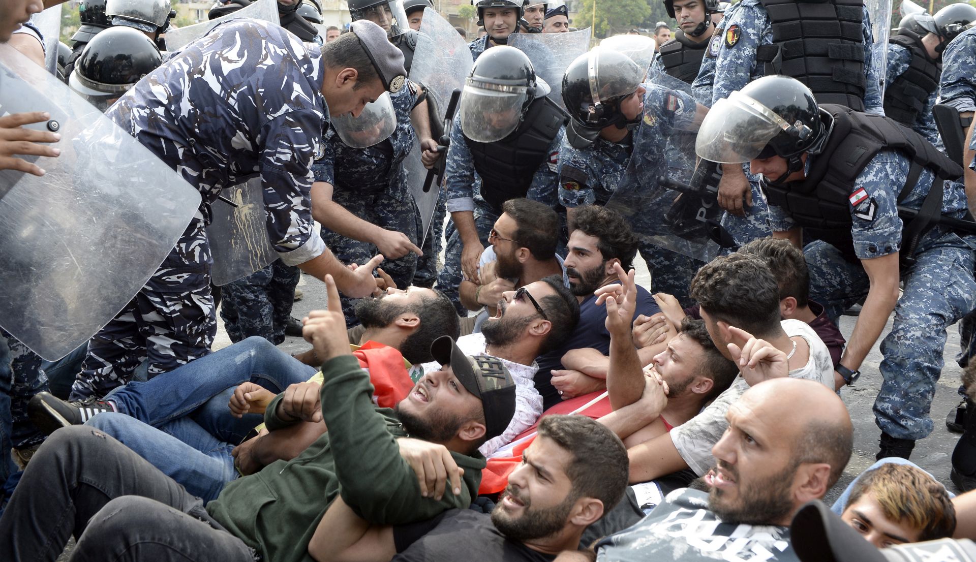 epa07950555 Lebanese riot policemen remove anti-government protesters blocking the main highway on the tenth day of protest in Beirut, Lebanon, 26 October 2019. Thousands continued to protest on the second week of demonstrations against proposals of tax hikes and state corruption, and calling for the resignation of the government.  EPA/WAEL HAMZEH