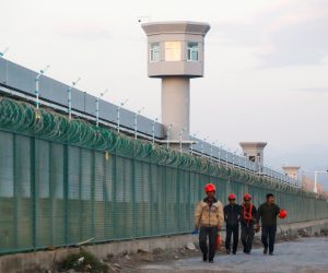 FILE PHOTO: Workers walk by the perimeter fence of what is officially known as a vocational skills education centre in Dabancheng FILE PHOTO: Workers walk by the perimeter fence of what is officially known as a vocational skills education centre in Dabancheng in Xinjiang Uighur Autonomous Region, China September 4, 2018. This centre, situated between regional capital Urumqi and tourist spot Turpan, is among the largest known ones, and was still undergoing extensive construction and expansion at the time the photo was taken. Picture taken September 4, 2018. REUTERS/Thomas Peter/File Photo Thomas Peter