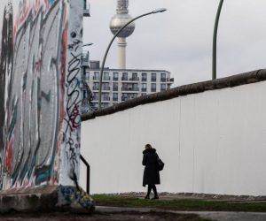 epa07972058 A visitor walks along a remaining section of the notorious Berlin Wall at the East Side Gallery in Berlin, Germany, 04 November 2019. The now German capital prepares for the celebrations marking the 30th anniversary of the fall of the Berlin Wall on 09 November 2019. Seen in background is the landmark TV tower at the Alex Square, in the former eastern part of the city.  EPA/OMER MESSINGER