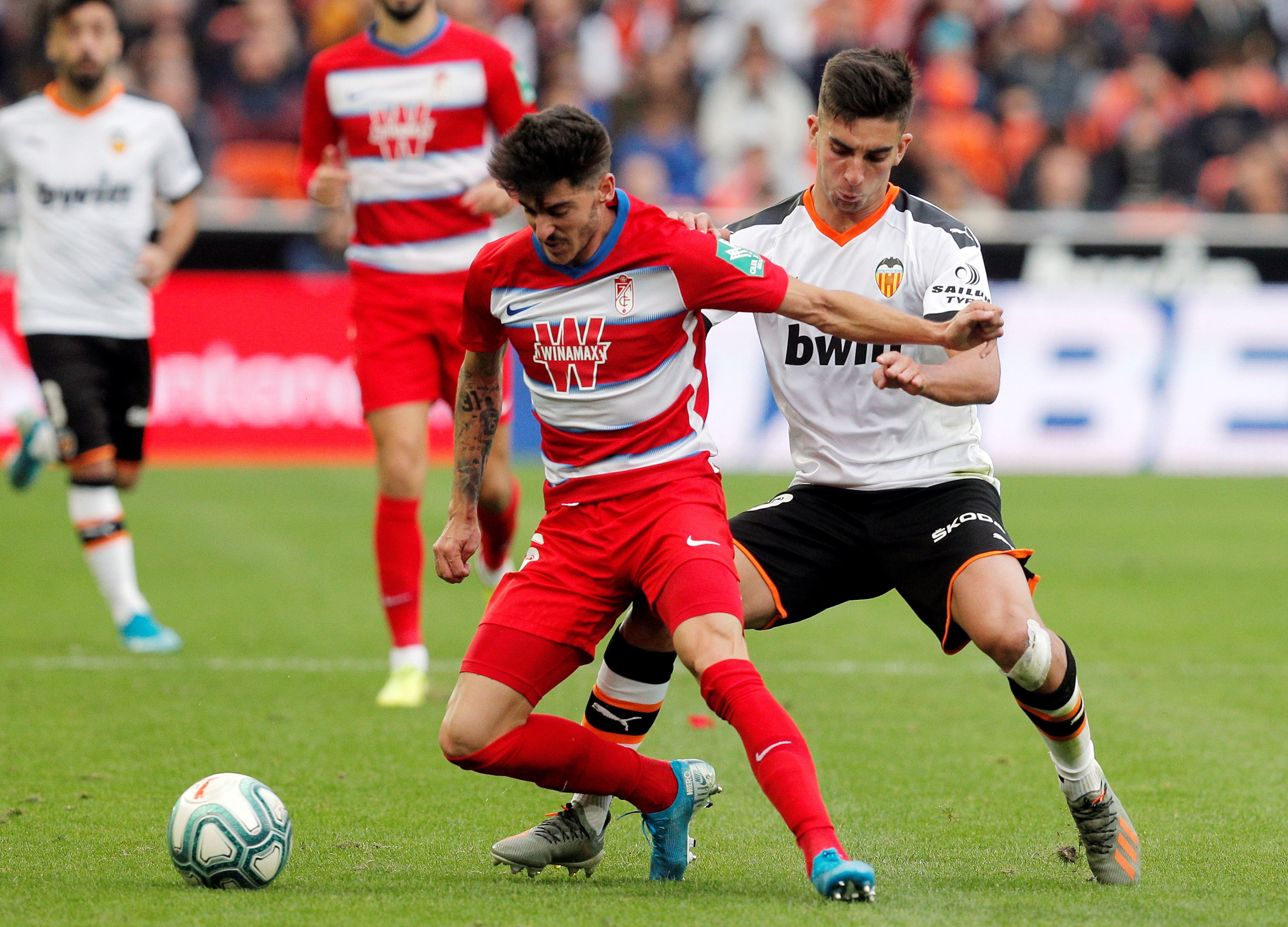 epa07983969 Valencia CF's midfielder Ferran Torres (R) duels for the ball with Granada CF's defender Carlos Neva (L) during their Spanish LaLiga Primera Division soccer match played at the Mestalla stadium in Valencia, eastern Spain, 09 November 2019.  EPA/Kai Foersterling