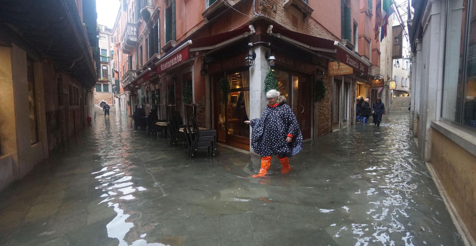 epa07990604 People wade through floodwaters in Venice, Italy, 12 November 2019. The high tide has already reached the level of 1 meter above sea level in Venice at 8 am.  EPA/ANDREA MEROLA