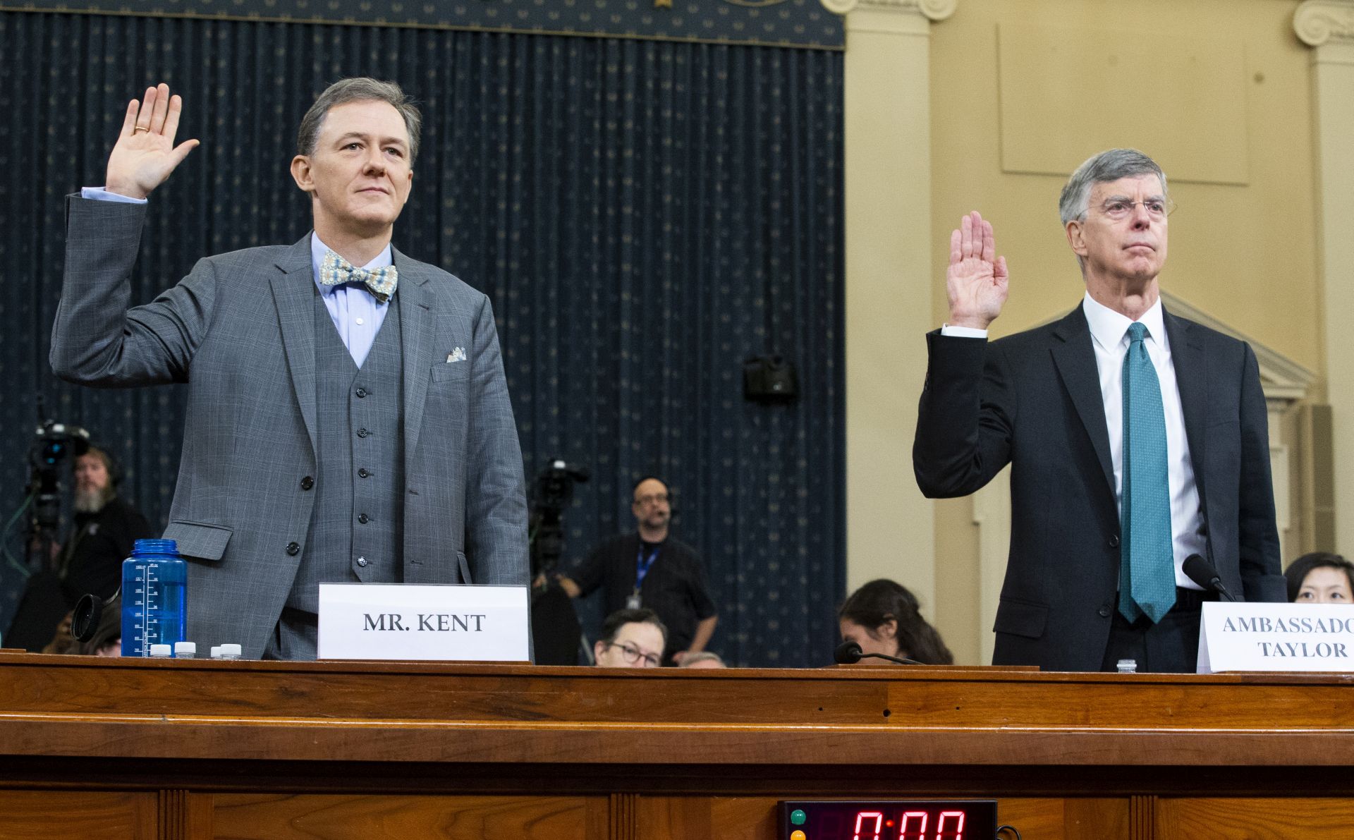 epa07993334 Charge d'Affaires at the US embassy in Ukraine Bill Taylor (R) and Deputy Assistant Secretary of State for Europe and Eurasia George Kent (L) are sworn-in to testify before the House Permanent Select Committee on Intelligence hearing on the impeachment inquiry into US President Donald J. Trump, on Capitol Hill in Washington, DC, USA, 13 November 2019. This is the first public hearing of the impeachment inquiry. The inquiry being led by three congressional committees was launched following a whistleblower's complaint that alleges US President Donald J. Trump requested help from the President of Ukraine to investigate a political rival, Joe Biden and his son Hunter Biden.  EPA/MICHAEL REYNOLDS