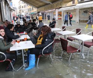 epa08003604 Tourists and residents resume their normal routine despite persistent flooding in Venice, Italy, 17 November 2019. High tidal waters returned to Venice on Saturday, four days after the city experienced its worst flooding in more than 50 years.  EPA/EMILIANO CRESPI