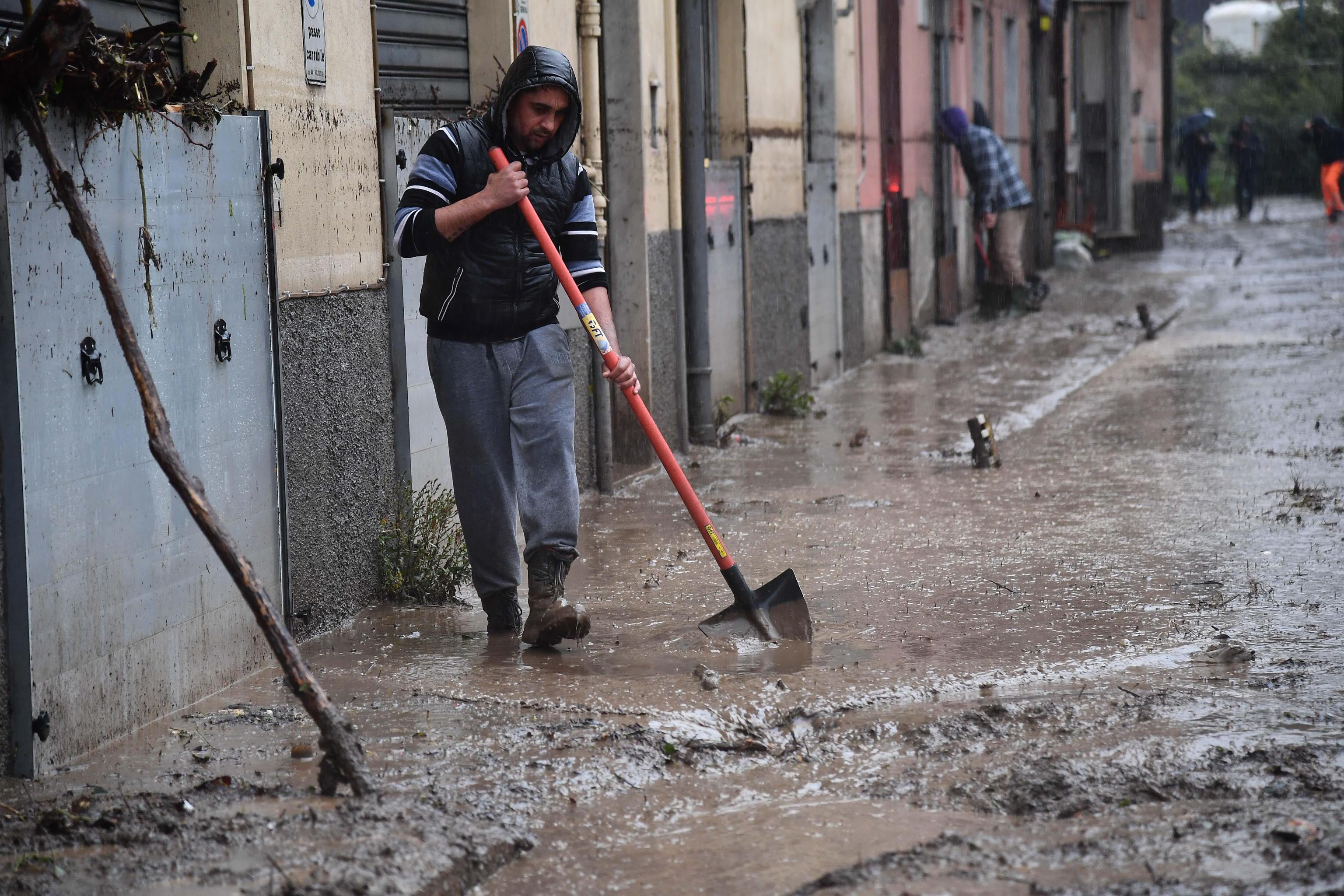 epa08019336 Locals clean up after floodings caused by bad weather in Genova, Italy, 23 November 2019.  EPA/LUCA ZENNARO