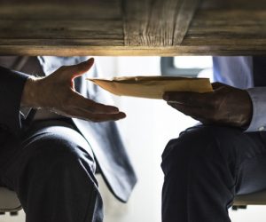 Business people sending documents under the table