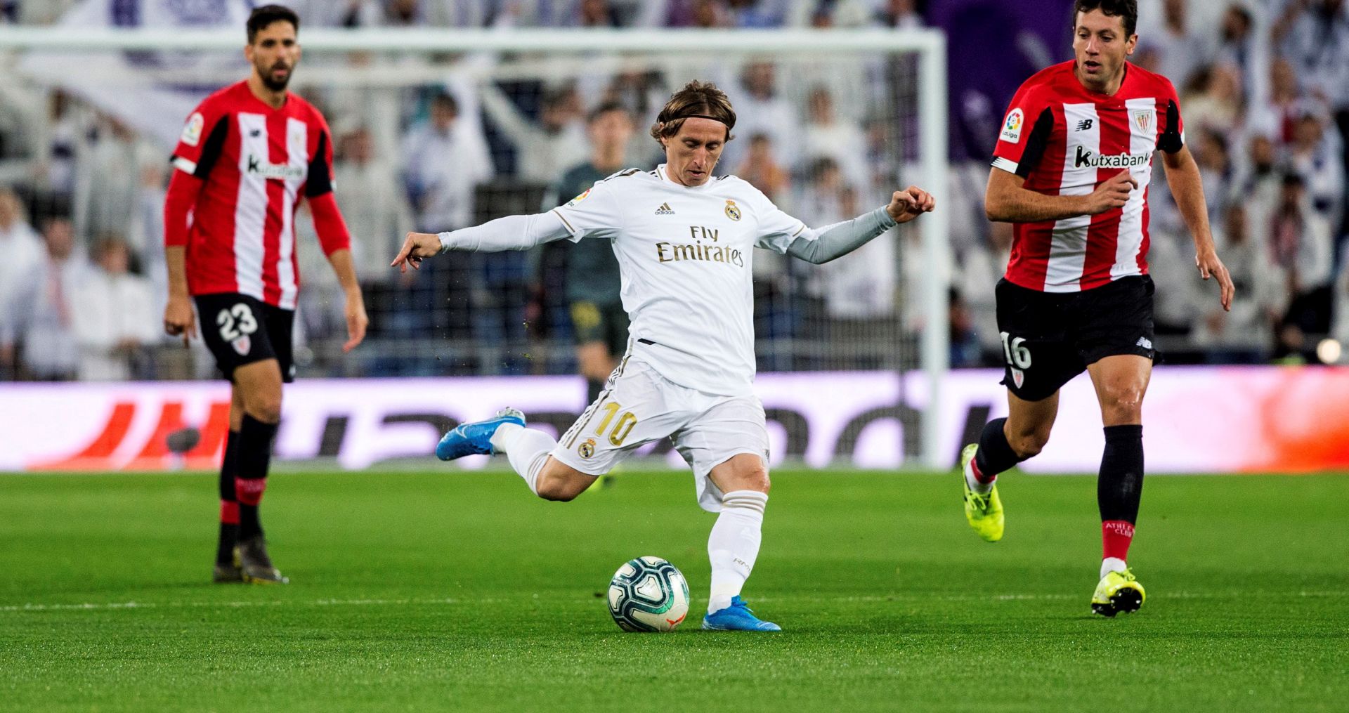 epa08087351 Real Madrid's Croatian midfielder Luka Modric (C) kicks the ball next to Athletic Club's Kenan Kodro (L) and Mikel Vesga (R) during their Spanish LaLiga Primera Division soccer match played at the Santiago Bernabeu stadium in Madrid, Spain, 22 December 2019.  EPA/Rodrigo Jimenez