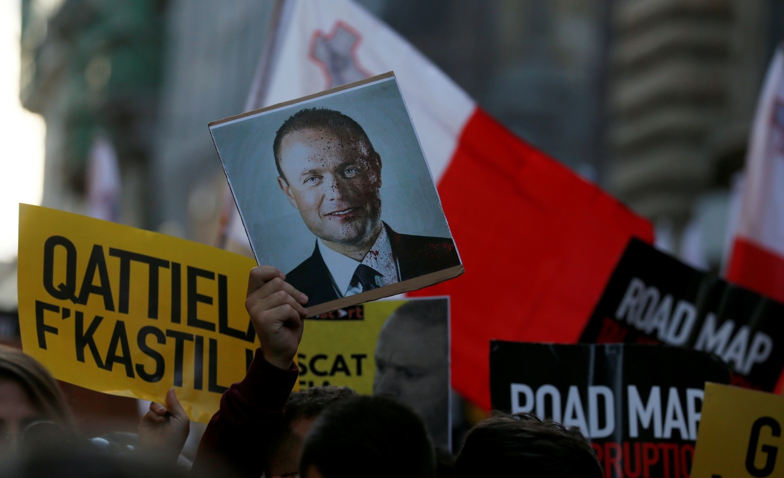 Demonstration to demand justice over the murder of journalist Daphne Caruana Galizia in Valetta A protester holds a picture of Maltese Prime Minister Joseph Muscat with his face covered in blood, next to a person holding a sign during a demonstration demanding justice over the murder of journalist Daphne Caruana Galizia outside the Parliament House, in Valletta, Malta, December 1, 2019. The sign reads, "Murderers in Castille" REUTERS/Darrin Zammit Lupi NO RESALES. NO ARCHIVES DARRIN ZAMMIT LUPI
