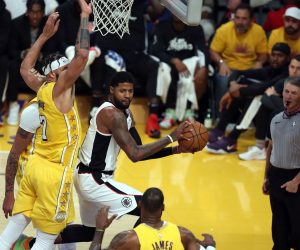 epa08090124 Los Angeles Clippers forward Paul George (C)  passes the ball past Los Angeles Lakers center JaVale McGee (L) and Los Angeles Lakers forward LeBron James (R, bottom) during the NBA basketball game between the Los Angeles Lakers and the Los Angeles Clippers at the Staples Center in Los Angeles, California, USA, 25 December 2019.  EPA/ADAM S DAVIS  SHUTTERSTOCK OUT