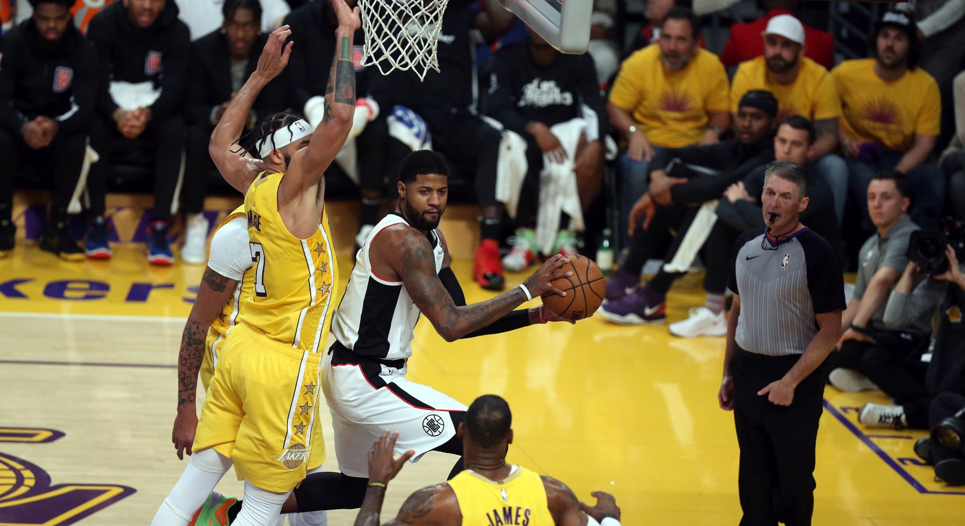epa08090124 Los Angeles Clippers forward Paul George (C)  passes the ball past Los Angeles Lakers center JaVale McGee (L) and Los Angeles Lakers forward LeBron James (R, bottom) during the NBA basketball game between the Los Angeles Lakers and the Los Angeles Clippers at the Staples Center in Los Angeles, California, USA, 25 December 2019.  EPA/ADAM S DAVIS  SHUTTERSTOCK OUT