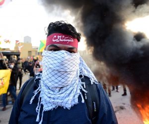 epa08098070 Members of Iran backed armed group Kataib Hezbollah (Hezbollah Brigades) set fire outside the U.S embassy inside the high security Green Zone area, in central Baghdad, Iraq, 01 January 2020. Supporters of Iranian-backed militias have withdrawn from the US Embassy in Baghdad following two days of sit-ins after a deadly US airstrike that killed 25 fighters of the Iran-backed militia on 29 December.  EPA/MURTAJA LATEEF