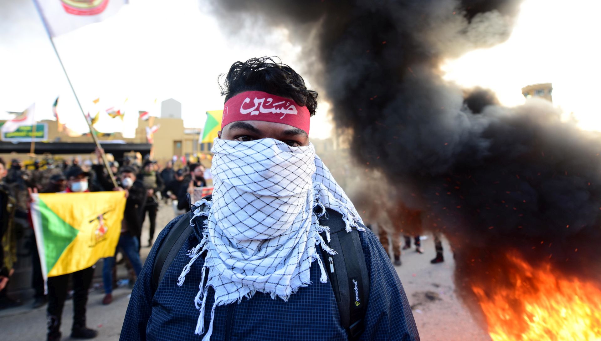 epa08098070 Members of Iran backed armed group Kataib Hezbollah (Hezbollah Brigades) set fire outside the U.S embassy inside the high security Green Zone area, in central Baghdad, Iraq, 01 January 2020. Supporters of Iranian-backed militias have withdrawn from the US Embassy in Baghdad following two days of sit-ins after a deadly US airstrike that killed 25 fighters of the Iran-backed militia on 29 December.  EPA/MURTAJA LATEEF