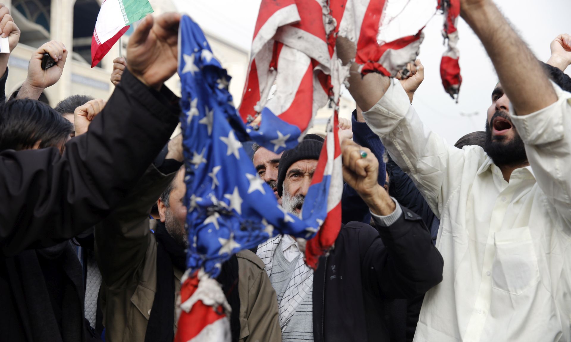 epa08099834 Iranians burn a US flag as thousands of people take to the streets to mourn the death of Iranian Revolutionary Guards Corps (IRGC) Lieutenant general and commander of the Quds Force Qasem Soleimani during an anti-US demonstration to condemn the killing of Soleimani, after Friday prayers in Tehran, Iran, 03 January 2020. The Pentagon announced that Iran's Quds Force leader Qasem Soleimani and Iraqi militia commander Abu Mahdi al-Muhandis were killed on 03 January 2020 following a US airstrike at Baghdad's international airport. The attack comes amid escalating tensions between Tehran and Washington.  EPA/ABEDIN TAHERKENAREH