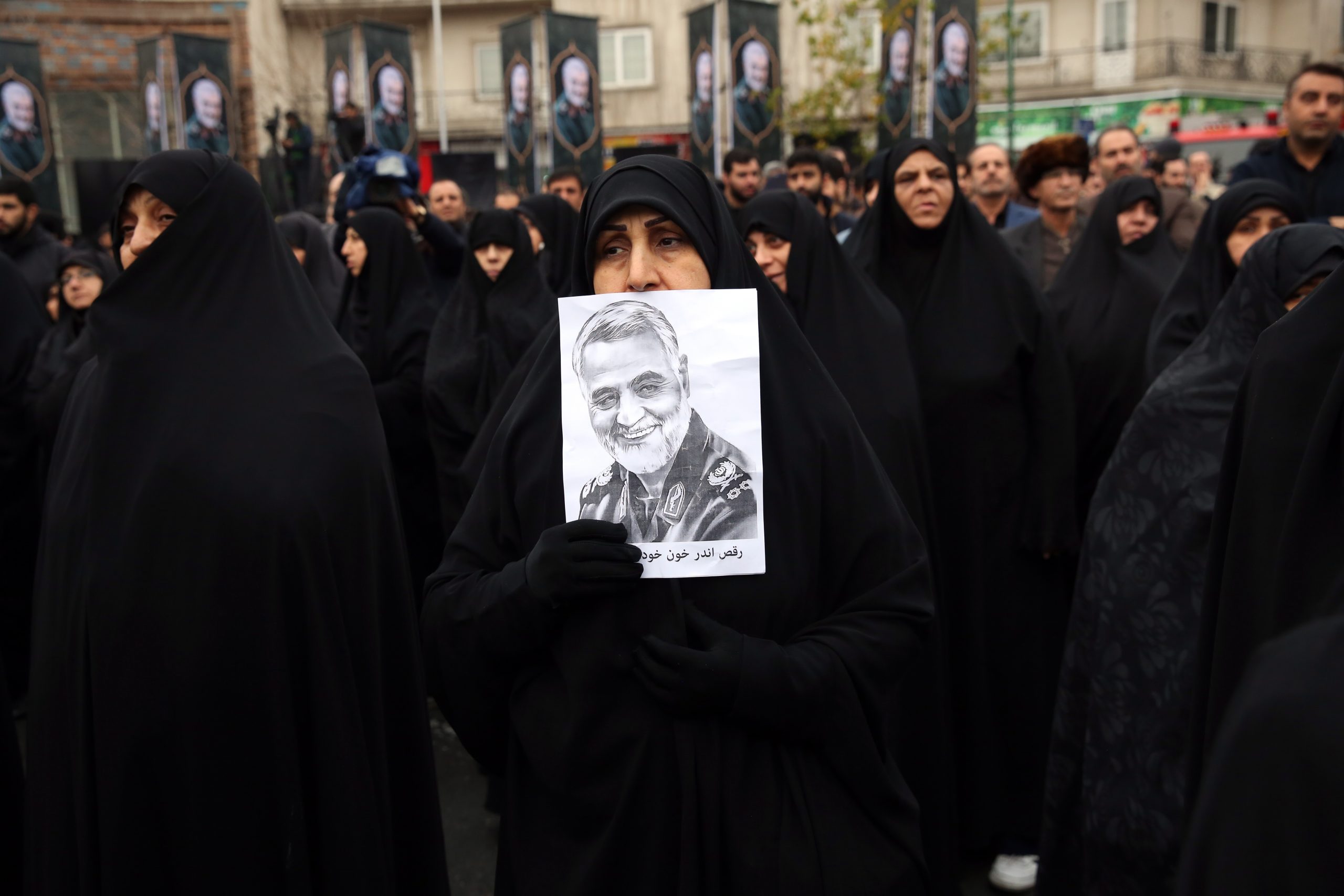 epaselect epa08102262 An Iranian woman as holds a picture depicting late Iranian Revolutionary Guards Corps (IRGC) Lieutenant general and commander of the Quds Force Qasem Soleimani  take part during anti-US protests in Tehran, Iran, 04 January 2020. The Pentagon announced that Iran's Quds Force leader Qasem Soleimani and Iraqi militia commander Abu Mahdi al-Muhandis were killed on 03 January 2020 following a US airstrike at Baghdad's international airport. The attack comes amid escalating tensions between Tehran and Washington.  EPA/ABEDIN TAHERKENAREH