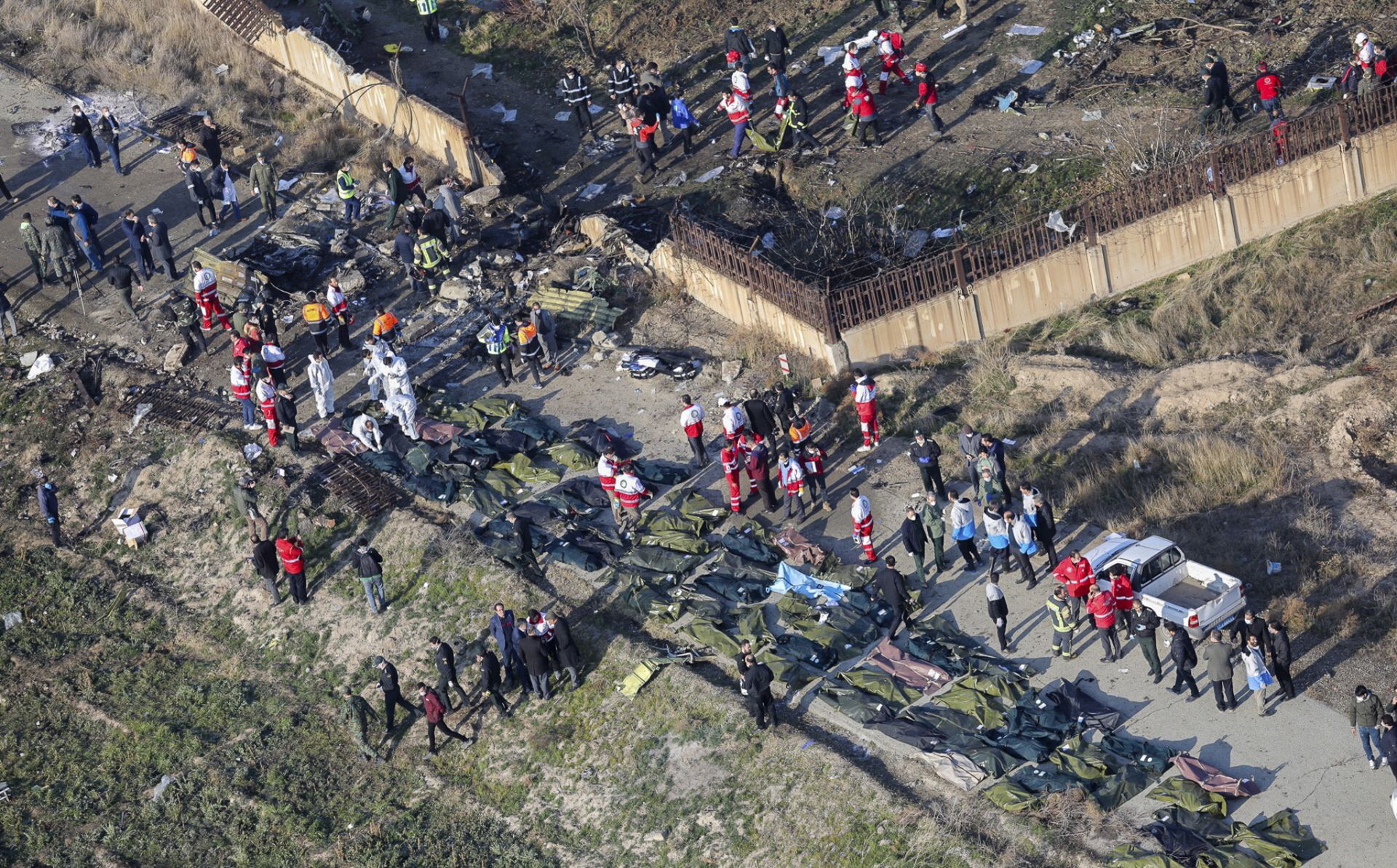 epaselect epa08111625 An areal view from a helicopter shows a general view of the crash site as members of emergency services workers and members of the International Red Crescent work next to the wreckage after an Ukraine International Airlines Boeing 737-800 carrying 176 people crashed near Imam Khomeini Airport in Tehran, killing everyone on board; in Shahriar, Iran, 08 January 2020.  EPA/RUHOLLAH VAHDATI