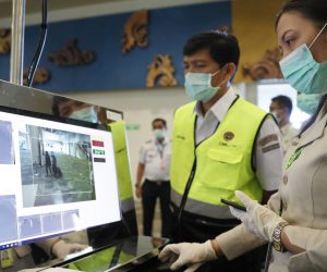 epa08149484 An officer inspects a monitor as passengers walk through a thermal scanner upon their arrival at Ngurah Rai International Airport in Kuta, Bali, Indonesia, 22 January 2020. According to media reports, at least six people have died, and 300 people are confirmed infected by a new respiratory virus which was first detected in Wuhan, China. The virus, called the coronavirus, can be passed between humans and has spread to the USA, Thailand, South Korea, Japan and Taiwan.  EPA/MADE NAGI