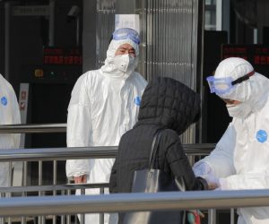 epa08161528 Security personnel wearing hazardous material suits measure body temperatures of passenger at the entrance of a subway station in Beijing, China, 25 January 2020. Two airports in Beijing will start to measure temperatures for arriving passengers from 25 January 2020 as the outbreak of coronavirus has so far claimed 41 lives and infected about 1300 others, according to media reports.  EPA/WU HONG