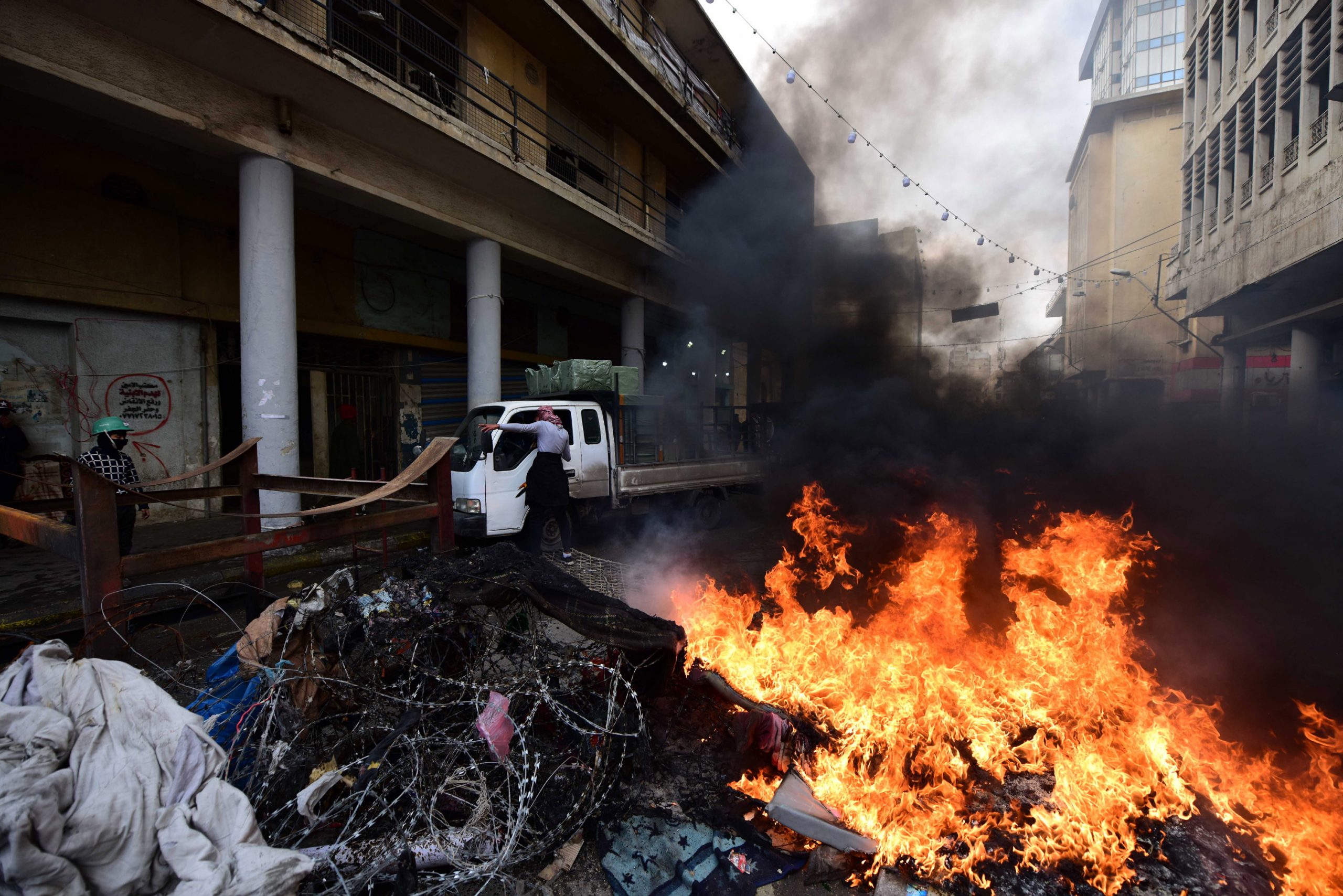 epa08162958 Iraqi protesters set fire to block a road during clashes with anti-riot police at the Al Tahrir square in central Baghdad, Iraq, 25 January 2020. At least seven protesters were wounded and dozens others were arrested, when Iraqi security forces stormed the main protest sites at Tahrir, Kilani, Tayaran squares, firing live rounds and tear gas at anti-government protesters. Iraqi activists said that the clashes took place after security forces began removing concrete blocks near Tahrir Square and on the Al-sinak bridge over the Tigris River in Baghdad and then advanced into Tahrir square and burned dozens of protesters tents.  EPA/MURTAJA LATEEF