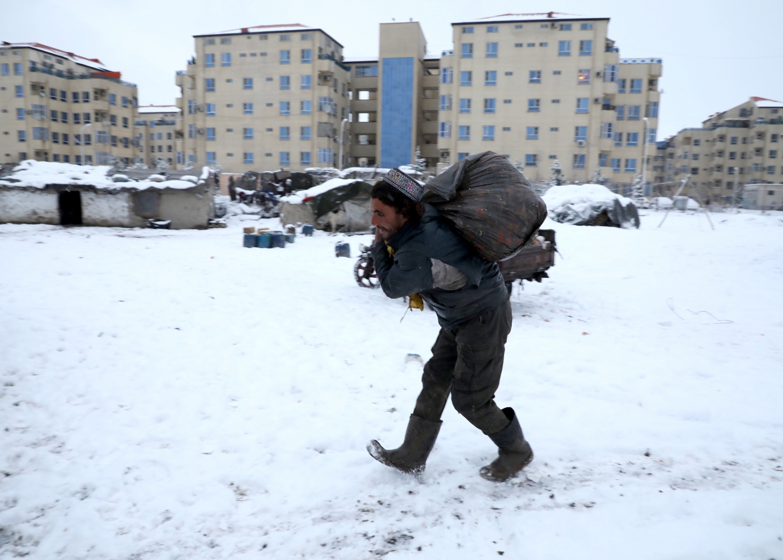 An Afghan man carries a sack on his back during a snowfall in Kabul An Afghan man carries a sack on his back during a snowfall in Kabul, Afghanistan January 12, 2020.  REUTERS/Omar Sobhani OMAR SOBHANI