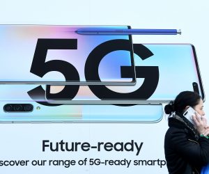epa08176144 A pedestrian walks past an advert displaying a 5G sign in London, Britain, 29 January 2020. The Government has decided to let the Chinese company Huawei to continue to be used in its 5G networks but with restrictions.  EPA/FACUNDO ARRIZABALAGA