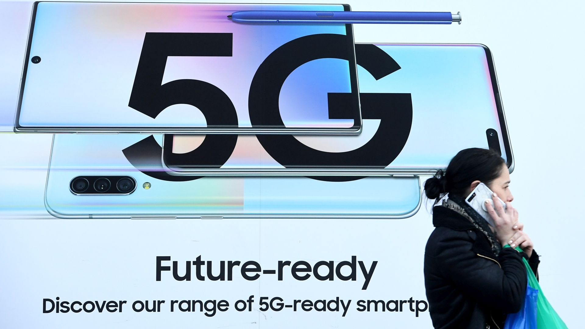 epa08176144 A pedestrian walks past an advert displaying a 5G sign in London, Britain, 29 January 2020. The Government has decided to let the Chinese company Huawei to continue to be used in its 5G networks but with restrictions.  EPA/FACUNDO ARRIZABALAGA