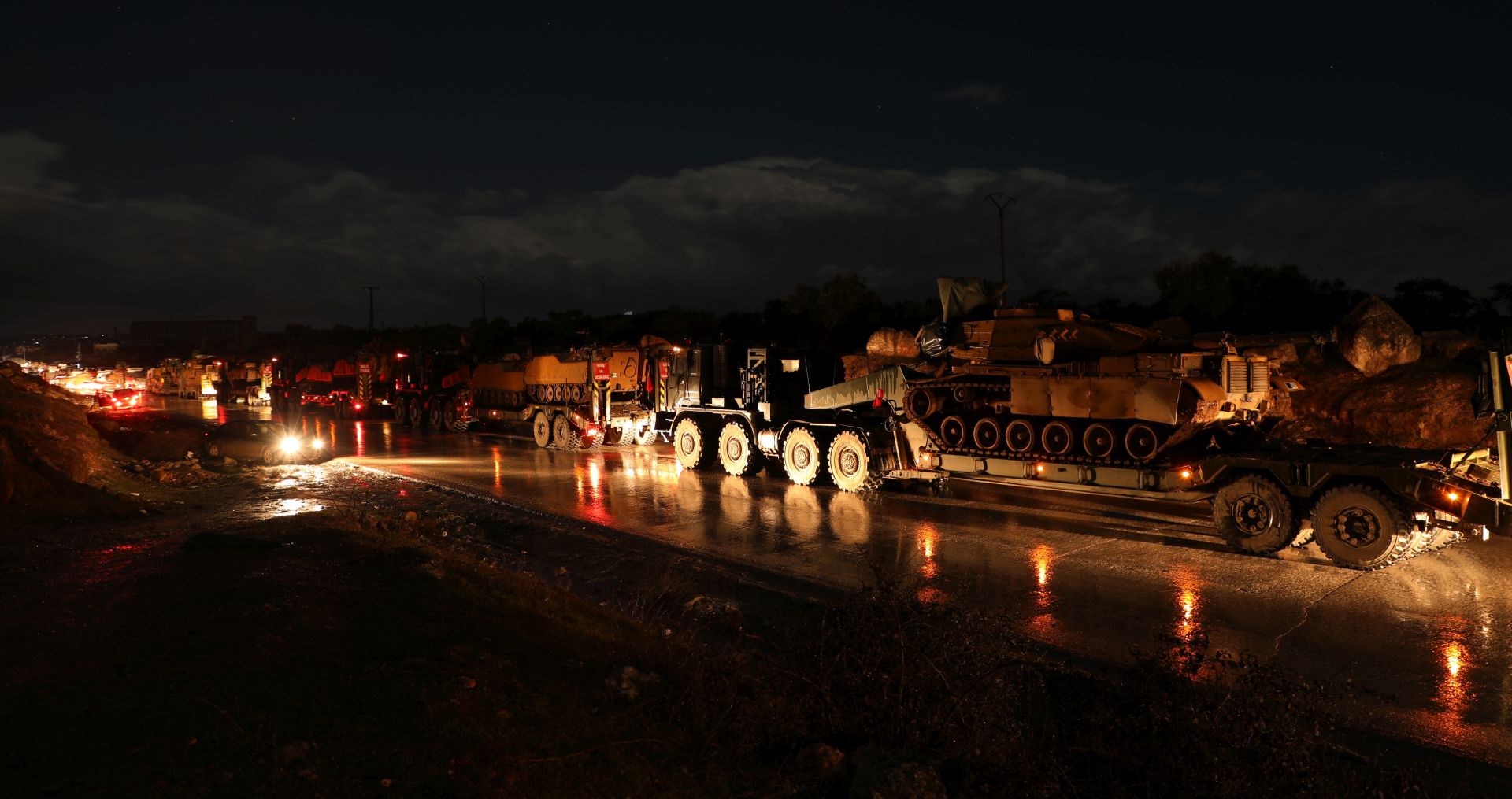 epa08202007 A view of a Turkish army military convoy as it reaches North East Idlib, Syria, late 07 February 2020. According to local media reports, some 150 Turkish army military vehicles of different kinds, which were stationed South and East of Idlib town moved on 07 February evening towards its northern part observation outpost.  EPA/YAHYA NEMAH