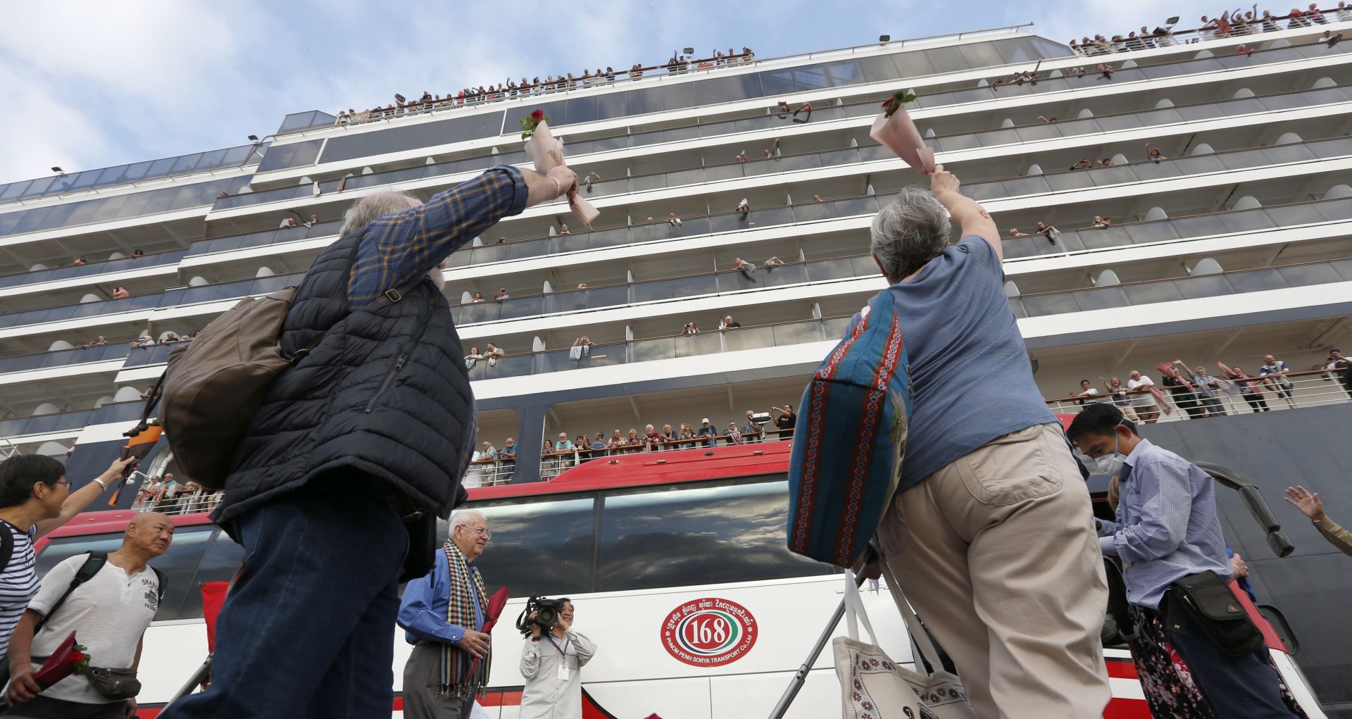 epaselect epa08216402 Passenger wave as they leave the MS Westerdam cruise ship at a seaport in Preah Sihanouk province, Cambodia, 14 February 2020. The Cambodian government allo?wed the MS Westerdam cruise ship, with about 2,000 passengers and crew aboard, to dock at Preah Sihanouk port on 14 February. The cruise ship was denied port by four countries over unsubstantiated reports that people infected with covid-19, were onboard.  EPA/MAK REMISSA