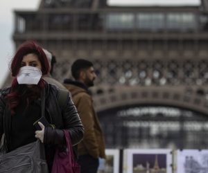 epa08219878 A woman wears a protective face mask near the Eiffel Tower, in Paris, France, 15 February 2020. The French Ministry of Health announced on 15 February that an 80-year-old Chinese tourist from Hubei province, who was hospitalized in intensive care at Bichat hospital in Paris in late January, had died from the novel coronavirus, marking the first death outside Asia of the virus.  EPA/IAN LANGSDON