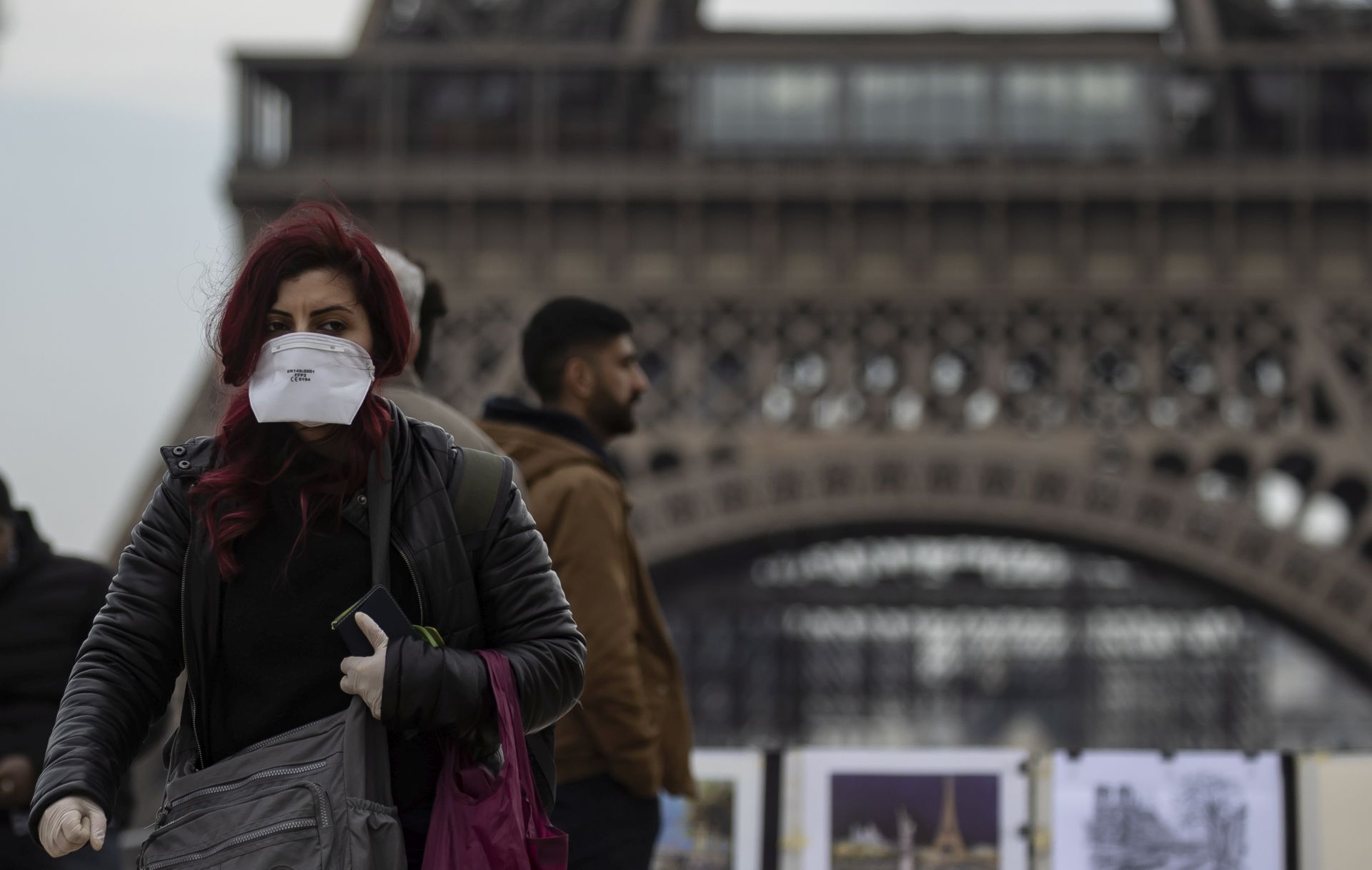 epa08219878 A woman wears a protective face mask near the Eiffel Tower, in Paris, France, 15 February 2020. The French Ministry of Health announced on 15 February that an 80-year-old Chinese tourist from Hubei province, who was hospitalized in intensive care at Bichat hospital in Paris in late January, had died from the novel coronavirus, marking the first death outside Asia of the virus.  EPA/IAN LANGSDON