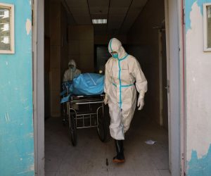 epa08223240 Workers move the body of a COVID-19 victim at a hospital in Wuhan, Hubei province, China, 16 February 2020. According to local authorities, the number of coronavirus cases in mainland China has reached 70,000 with more than 1,660 related deaths.  EPA/STRINGER CHINA OUT