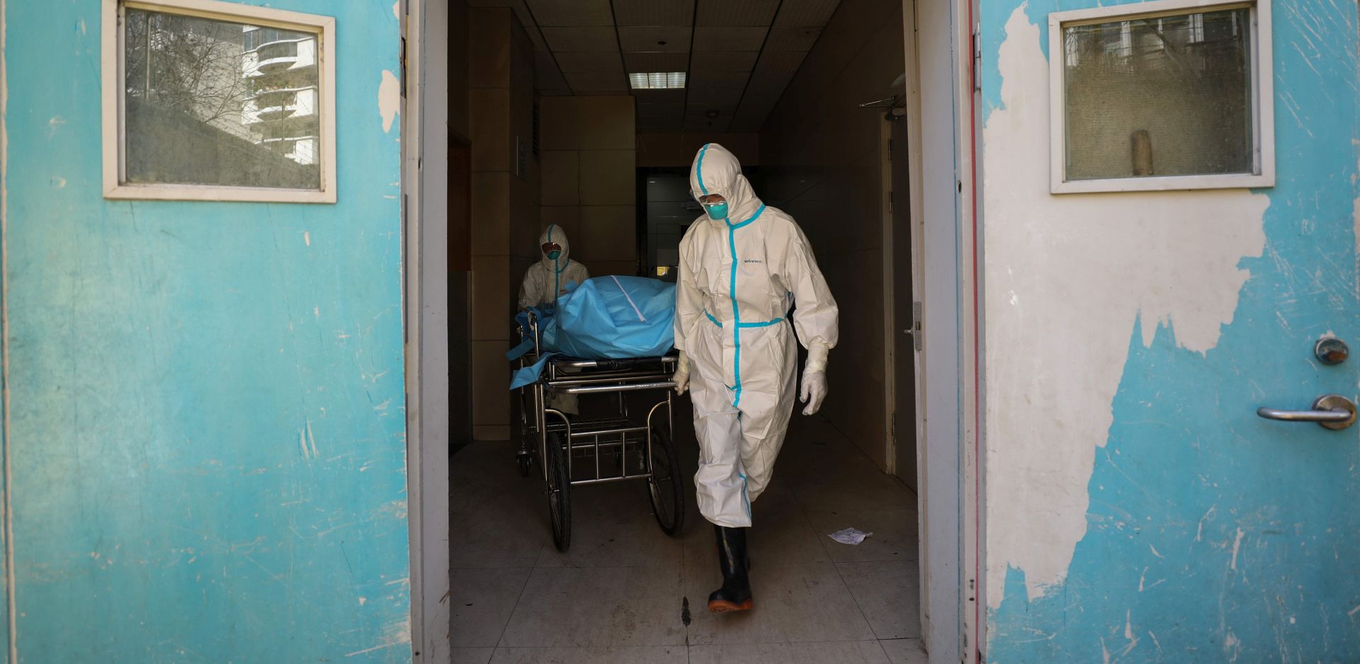 epa08223240 Workers move the body of a COVID-19 victim at a hospital in Wuhan, Hubei province, China, 16 February 2020. According to local authorities, the number of coronavirus cases in mainland China has reached 70,000 with more than 1,660 related deaths.  EPA/STRINGER CHINA OUT