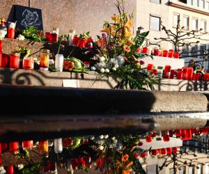21 February 2020, Hessen, Hanau: Flowers and candles are placed near one of the two shisha bars after the shooting in Hanau. Nine people of foreign descent were killed in a pair of attacks before the alleged shooter returned to his home and killed himself and his 72-year-old mother. Photo: Nicolas Armer/dpa