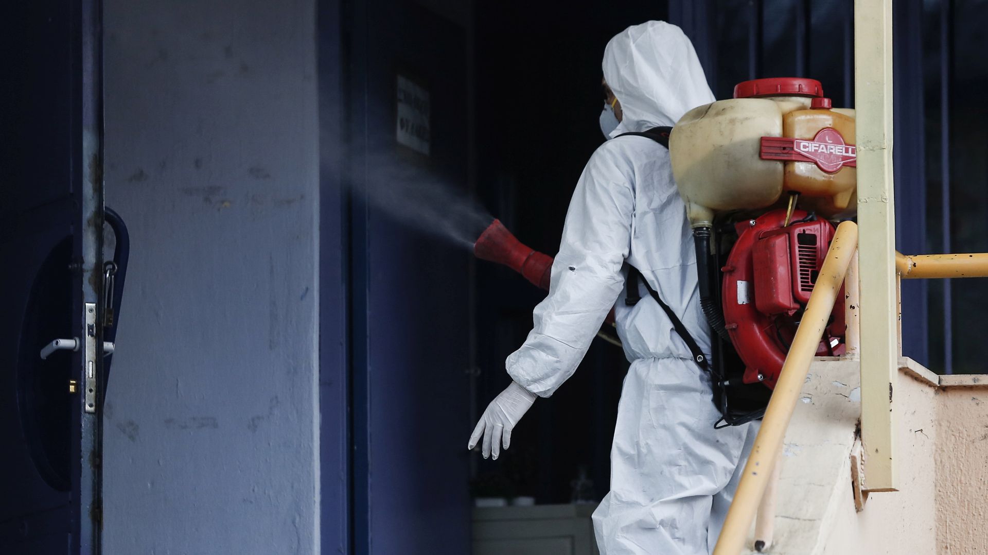 epa08253342 A man wearing a protective suit decontaminates a primary school where a child was diagnosed with coronavirus, Thessaloniki, Greece, 27 February 2020. The health ministry on Thursday announced two new cases of COVID-19 in the country, raising the number of patients taken ill with the virus to three.  EPA/DIMITRIS TOSIDIS