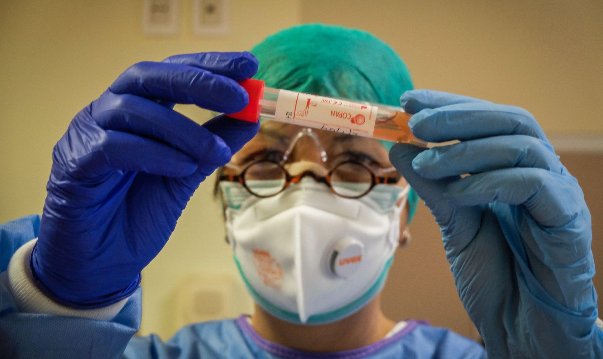 epa08264928 A healthcare professional wearing a protective suit and a healthcare mask inspects a vial containing a swab sample in a novel coronavirus Covid-19 testing laboratory in the infectious diseases ward at the Cremona hospital, in Cremona, northern Italy, 02 March 2020. The coronavirus deaths in Italy have reached over 30 as the number of people infected in the country has soared to more than 1,500.  EPA/MATTEO CORNER