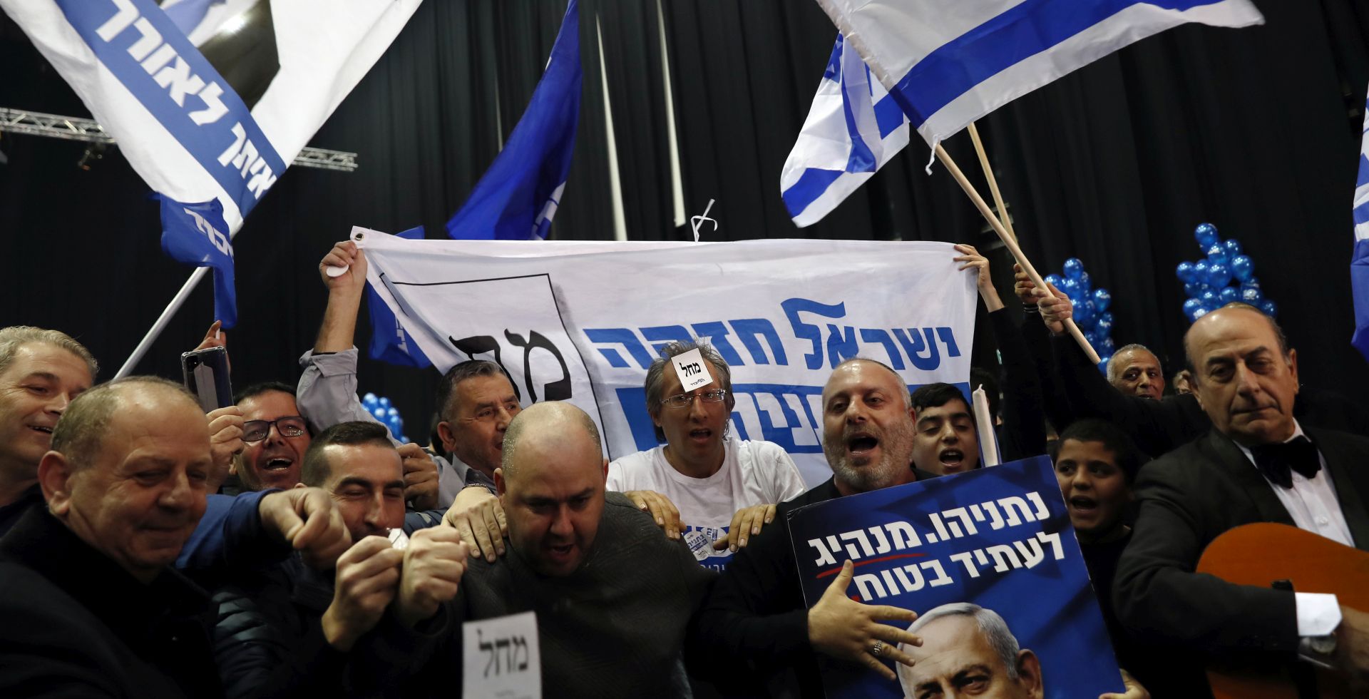 epa08265527 Supporters of Israeli Prime Minister and Chairman of the Likud Party Benjamin Netanyahu (not pictured) celebrate at the Likud party final election event after early exit polls in the third parliament election in one year, in Tel Aviv, Israel, 03 March 2020. Exit polls indicate that Benjamin Netanyahu's Likud Party will be able to form a government with a 60-seat bloc over opposition leader Benny Gantz's Blue and White Party.  EPA/ATEF SAFADI