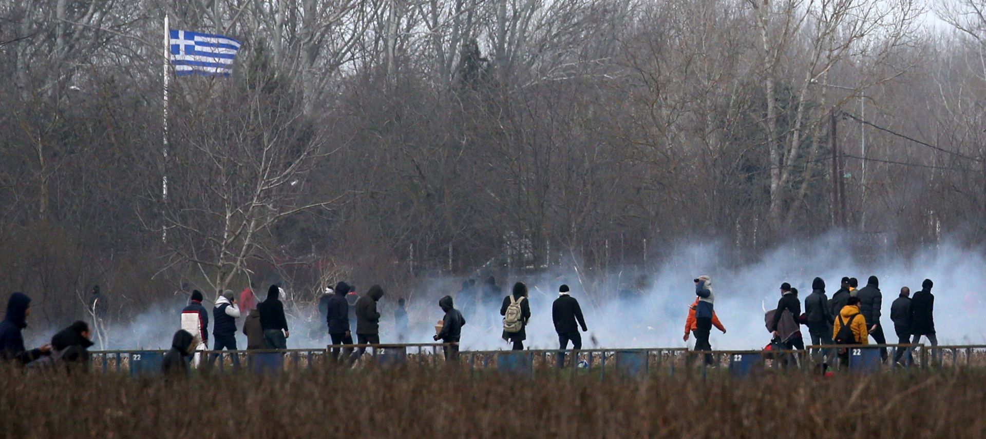 epa08268550 Migrants run from tear gas employed by Greek police officers as they attempt to cross the closed-off Turkish-Greek border in a bid to reach European soil, in Edirne, Turkey, 04 March 2020. Thousands of refugees and migrants are gathering on the Turkish side of the border with Greece with the intention of crossing into the European Union following the Turkish government's decision to loosen controls on migrant flows after the death of 33 Turkish soldiers killed in an attack in Idlib, Syria, on 27 February 2020.  EPA/ERDEM SAHIN
