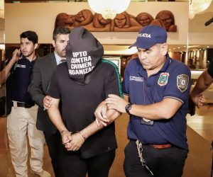 epa08270860 Brazilian citizen Wilmondes Sousa (C) is arrested on charges of providing false passports on behalf of former professional soccer player Ronaldinho and his brother Assis, outside the hotel where Ronaldinho is staying in Asuncion, Paraguay, 04 March 2020. The Paraguayan Prosecutor's Office ordered the arrest of Ronaldinho for alleged possession of altered passports, hours after the Brazilian former player entered Paraguay. Ronaldinho was allowed to remain in his hotel under custody.  EPA/NATHALIA AGUILAR